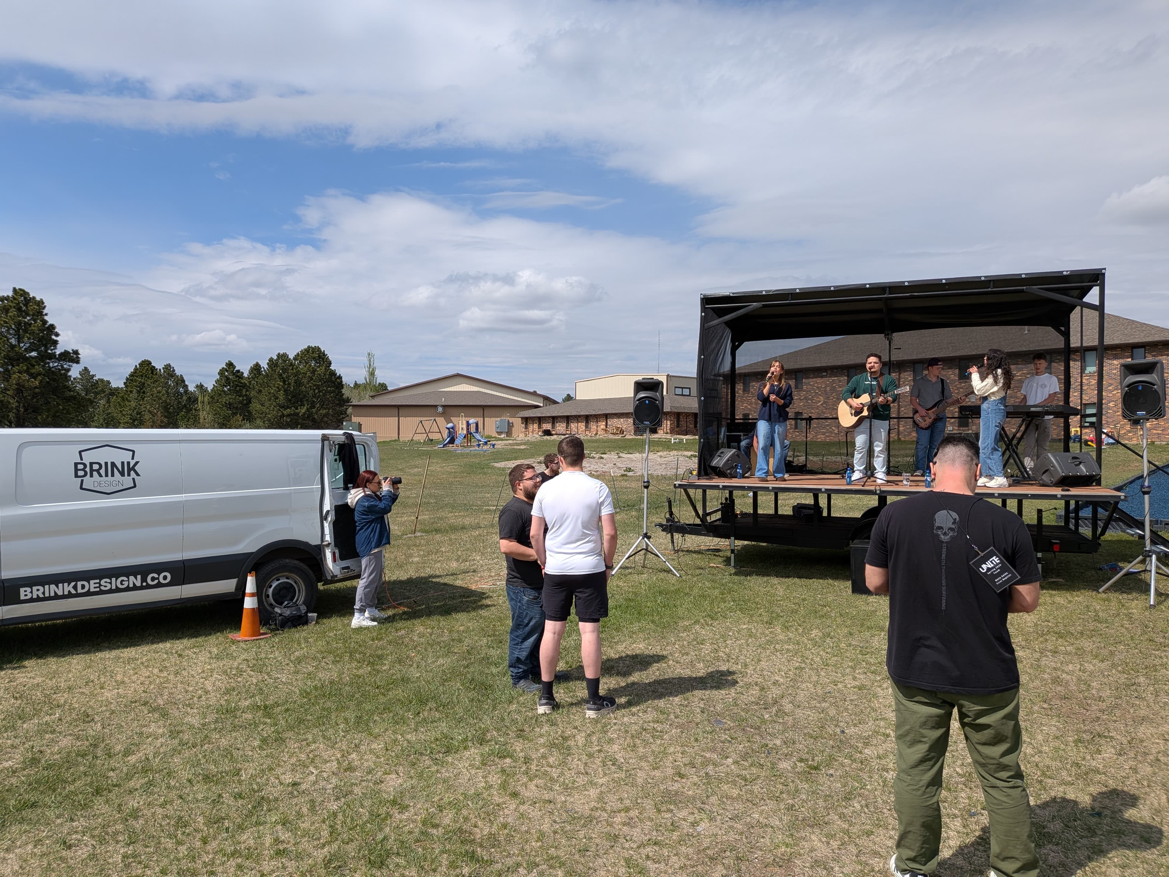 Brink branded van and portable stage at an outdoor worship event in the Black Hills